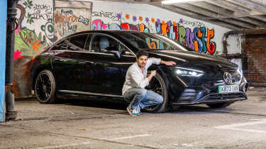 Auto Express senior staff writer Jordan Katsianis crouching next to the Mercedes EQE